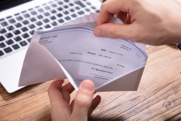 persons-hand-removing-paycheck-from-the-envelope-picture